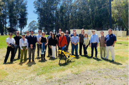 The I&E Council tour group standing in a eucalyptus grove at Richmond Field Station with a robotic dog