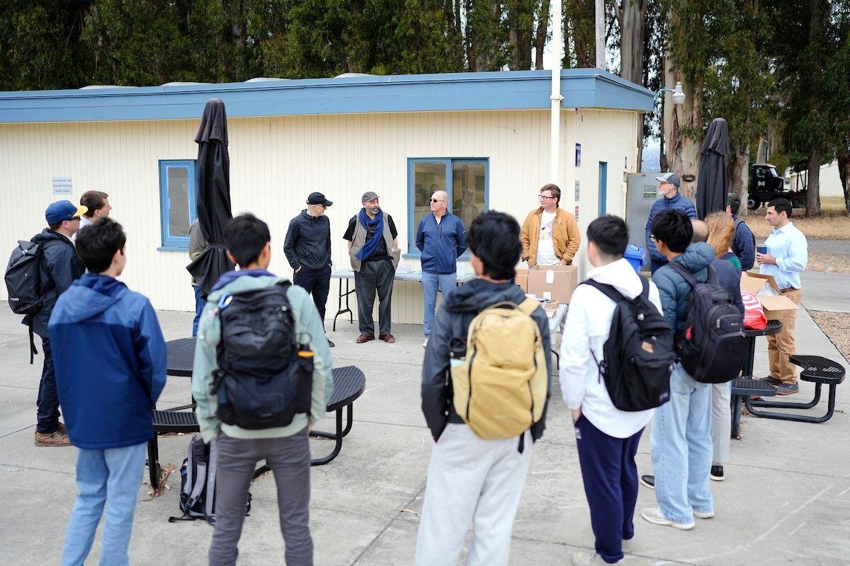 Coordinators briefing students outdoors at the start of the M-DOC workshop