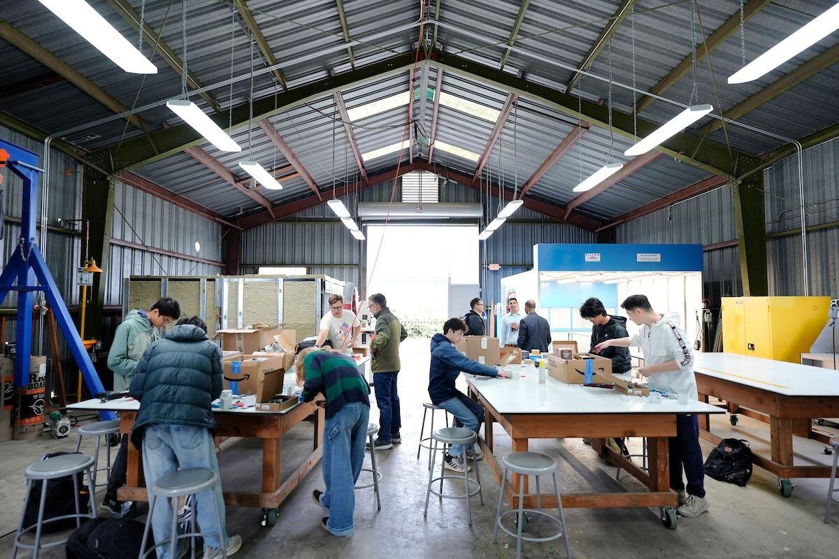 Students assembling drones at workbenches inside the SOAR fabrication shop