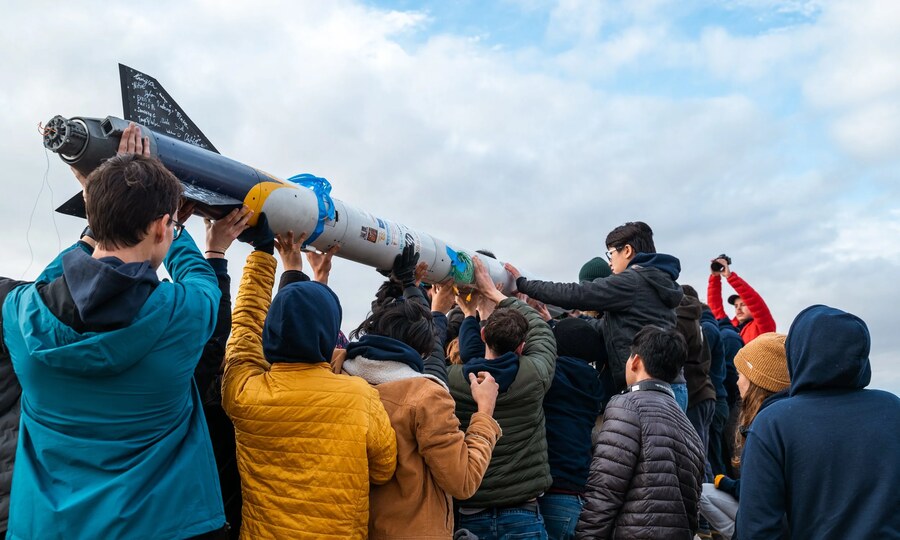 Space Enterprises at Berkeley students lifting a rocket airframe during build prep